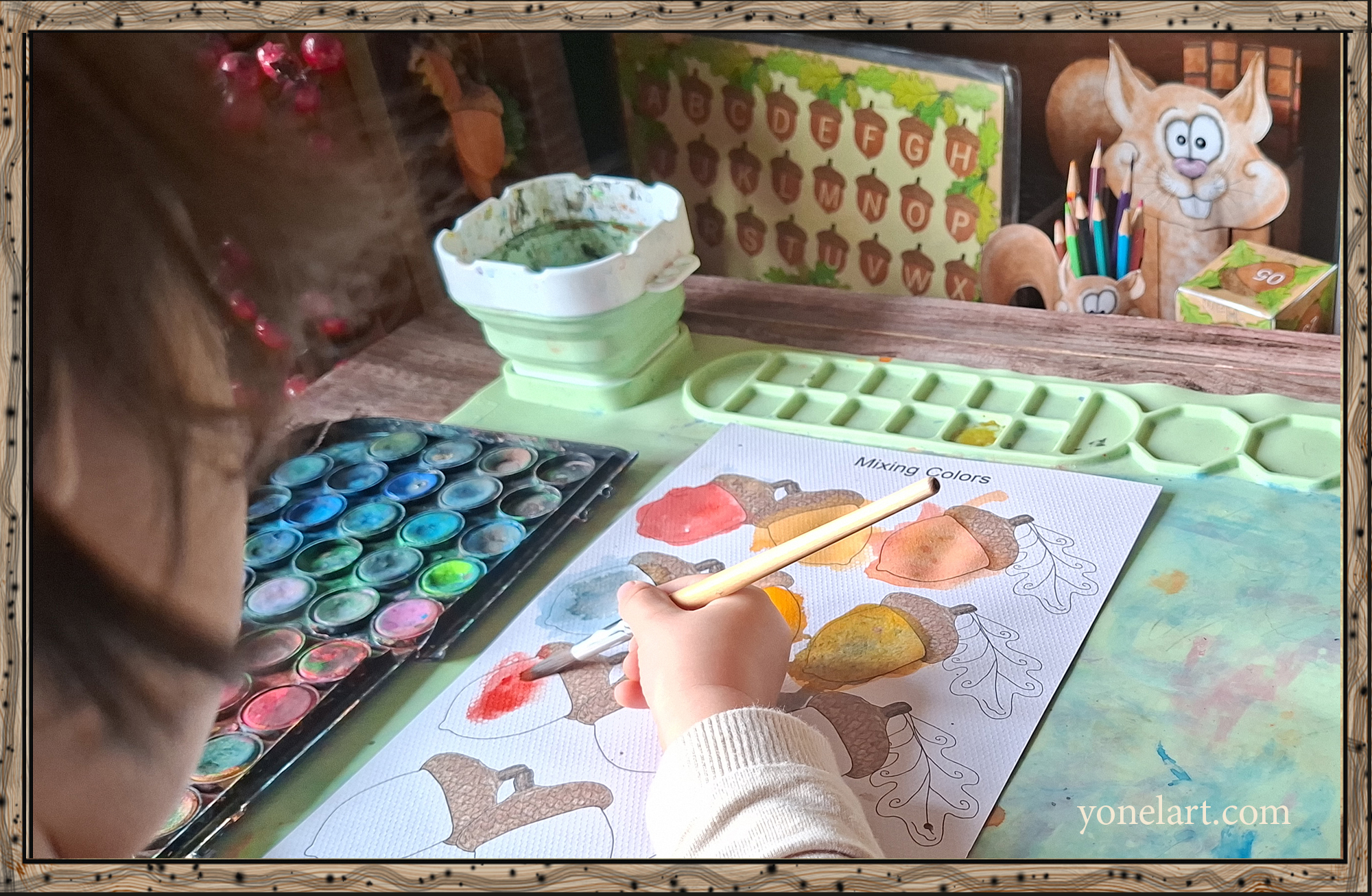 Child mixing colors with a paintbrush and watercolors using a printable color mixing worksheet